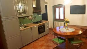 cocina con mesa de madera y mesa pequeña con sillas en La Suite dei Ricordi, en Impruneta