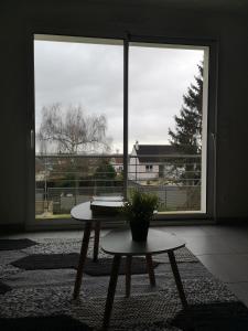 a room with a table in front of a large window at Maison récente calme lumineuse 24 heures du Mans 9 couchages in Le Mans