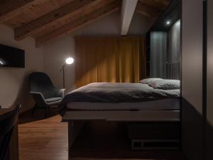 ツェルマットにあるMalteserhaus Zermattのベッドルーム1室(ベッド1台、椅子付)