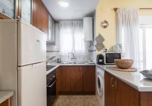 kuchnia z białą lodówką i zlewem w obiekcie Apartamento frente al Mar - 500 MBPS w mieście Puerto de Sagunto
