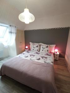 a bedroom with a large bed with two lamps on it at la frégate blanche in Concarneau