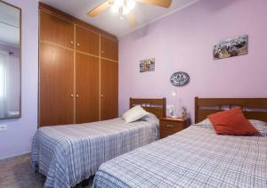 sypialnia z 2 łóżkami i zegarem na ścianie w obiekcie Apartamento frente al Mar - 500 MBPS w mieście Puerto de Sagunto