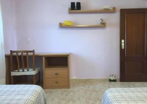 1 dormitorio con escritorio, silla y cama en Apartamento frente al mar - 500 Mbps, en Puerto Sagunto