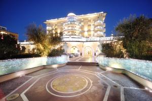 un grande edificio con un orologio davanti di Palace Hotel a Milano Marittima