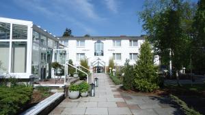 a large white building with a pathway in front of it at R&R Hotel Störtebeker in Baabe