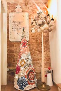 Un árbol de Navidad junto a una pared con una señal en Spello House Dormio, en Spello