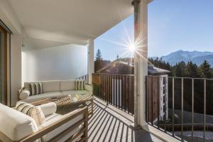 d'un balcon avec un canapé et une vue sur les montagnes. dans l'établissement LAAX Homes - Taviarna Laax 4,5, à Laax