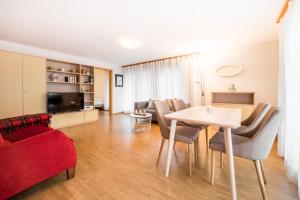 sala de estar con mesa y sofá rojo en LAAX Homes - Val Mulin 8,2 - Scarpazza, en Laax