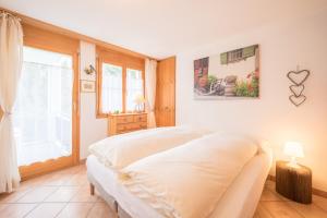 ラアにあるLAAX Homes - Val Mulin 14,1 - Accerneroのベッドルーム(白いベッド1台、窓付)