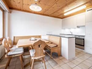 una cucina con tavolo e sedie in legno di LAAX Homes - Val Signina 1-13a a Laax