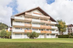 ラアにあるLAAX Homes - Val Signina 1-13aのバルコニー付きの白いアパートメントです。
