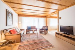 a living room with a couch and a tv at LAAX Homes - Val Signina 1-13a in Laax