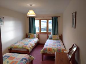 a room with two beds and a window at Llinos Cottage in Beaumaris