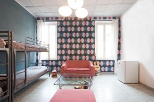 ローマにあるサラズ B＆Bの二段ベッド、椅子、テーブルが備わる客室です。