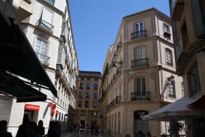 una via cittadina con edifici e persone che camminano per strada di Mar y Arte Apartamentos a Málaga