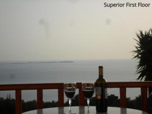 a bottle of wine sitting on a table with two glasses at Mediterranean Studios in Lassi