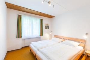 ラアにあるLAAX Homes - Val Signina 4-8のベッドルーム1室(ベッド2台、窓付)