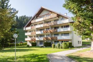 apartamentowiec z balkonem i trawnikiem w obiekcie LAAX Homes - Val Signina 4-8 w mieście Laax