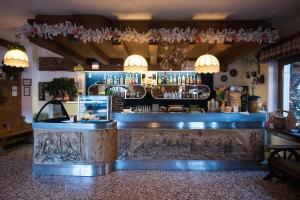 a bar in a restaurant with a counter and lights at Hotel Sport in Sappada