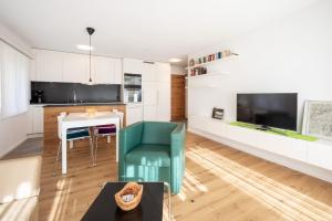een keuken en een woonkamer met een tafel en stoelen bij Val Signina 5-2 in Laax