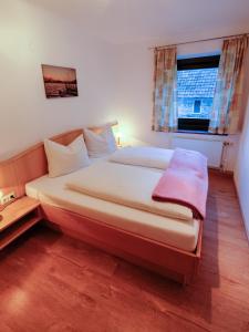 ein großes Bett in einem Schlafzimmer mit Fenster in der Unterkunft Haus Hubertus in Radnig