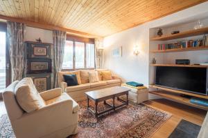 uma sala de estar com um sofá e uma televisão em LAAX Homes - Val Signina 8-17 em Laax