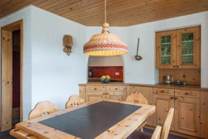 ラアにあるLAAX Homes - Val Signina 8-18のキッチン(木製テーブル、ペンダントライト付)