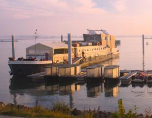 a large boat is docked at a dock in the water at Botel Ophoven in Kinrooi