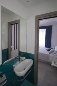 a bathroom with a sink and a bed and a mirror at ChiàRò-La casa al mare in Minori