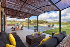 a patio with a couch and a table and a pool at Finca Maria in Manacor