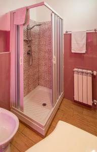 una doccia in un bagno rosa con lavandino di B & B San Cataldo a San Cataldo