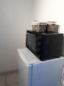 eine schwarze Mikrowelle auf einem Kühlschrank in der Unterkunft Jardin d elisa in Chevetogne