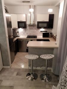 a kitchen with a counter and two stools in it at Górski Apartament in Karpacz