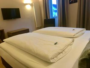 two beds in a hotel room with white sheets at Gasthaus Schwan in Riedenburg