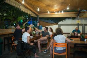 eine Gruppe von Personen, die in einer Bar in einem Restaurant sitzen in der Unterkunft Ostello Bello Bagan Pool in Bagan