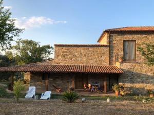 una casa de ladrillo con sillas y una chimenea frente a ella en Casa vacanze Il Mandorlo, en Perdifumo