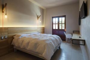 a bedroom with a bed and a desk and a television at Comala Bed & Breakfast in Oaxaca City