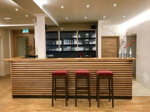 a bar with red stools in a restaurant at Gasthaus Schwan in Riedenburg