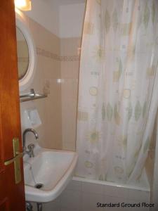 a bathroom with a sink and a shower curtain at Mediterranean Studios in Lassi