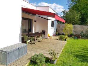 a backyard with a wooden deck with a table at Chambres privées proche DISNEY Parcs in Chanteloup-en-Brie