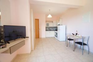 a kitchen and dining room with a table and a television at Fotini in Ayia Evfimia