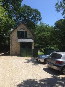 two cars parked in front of a brick house at Appart'Village Jouy La longère in Jouy-en-Josas