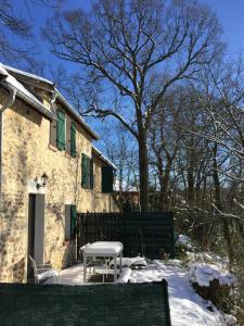 a table and chair in the snow in front of a house at Jouy La longère, proche Hec, Versailles, parking privé gratuit in Jouy-en-Josas
