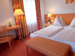 a hotel room with a bed and a table and a desk at Motel55 - nettes Hotel mit Self Check-In in Villach, Warmbad in Villach