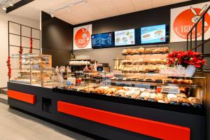 a bakery with a display case filled with lots of pastries at Apart Hotel Messe Munich - my room Apartments in Munich