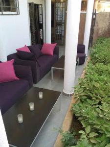 a living room with purple couches and pink pillows at Le ZaNaLi Hotel in Ouagadougou