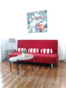 a red couch with pillows and a table in a room at Inglesinhos 1 in Lisbon