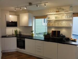a kitchen with white cabinets and a black counter top at Central location in the heart of historic Bergen in Bergen