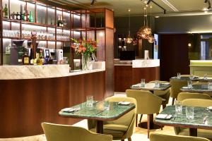 a restaurant with tables and chairs and a bar at My Story Hotel Augusta in Lisbon