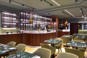 a restaurant with tables and chairs and a bar at My Story Hotel Augusta in Lisbon